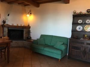 a living room with a green couch and a fireplace at Gelsomini in Massa