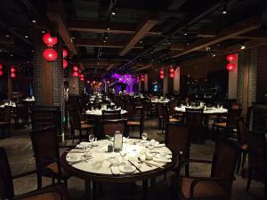 uma sala de jantar com mesas e cadeiras e luzes vermelhas em Grand Pacific Hotel Ningbo em Yuyao