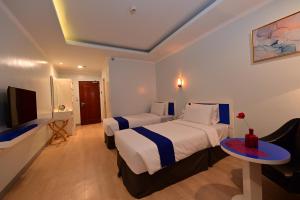 A bed or beds in a room at T Shine Resort and Spa
