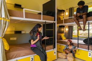 a group of people sitting on bunk beds in a room at The Hosteller Kareri in Dharamshala