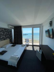 a bedroom with a bed and a view of the ocean at Pensiunea Maria Costinesti in Costinesti