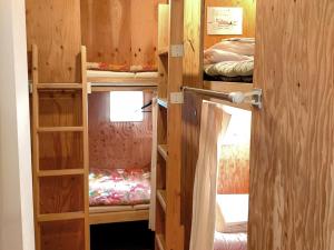 a room with three bunk beds and a door open at Saga International Guesthouse Hagakure in Saga
