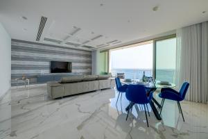 a living room with a couch and a table and chairs at Super Luxury Apartment in Tigne Point, Amazing Sea Views in Sliema