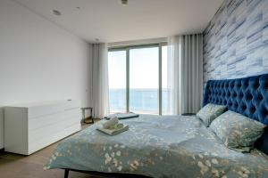 a bedroom with a blue bed and a large window at Super Luxury Apartment in Tigne Point, Amazing Sea Views in Sliema +59 photos