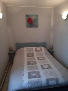 1 dormitorio con 1 cama con edredón en La-Haut, gite-maison de vacances, en Poinson-lès-Fays