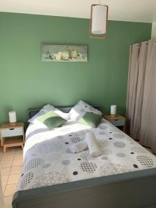 Sainte-Marguerite的住宿－Maison chaleureuse à proximité de la mer，一间卧室设有一张带绿色墙壁的床