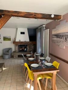 Maison chaleureuse à proximité de la mer في Sainte-Marguerite: غرفة طعام مع طاولة خشبية وكراسي صفراء