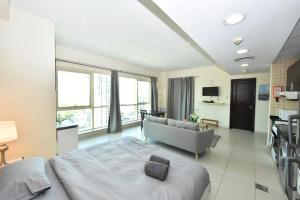 a large bedroom with a bed and a couch at Furnished studio with balcony in Marina -JMI in Dubai