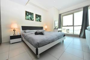 a bedroom with a bed and a large window at Furnished studio with balcony in Marina -JMI in Dubai