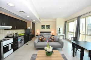 a kitchen and living room with a couch and a table at Furnished studio with balcony in Marina -JMI in Dubai
