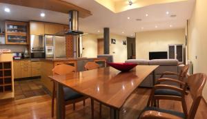 een keuken en eetkamer met een houten tafel en stoelen bij Duplex Monforte in Monforte de Lemos