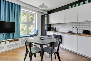 een keuken met witte kasten en een tafel en stoelen bij 4 Lions Grobla in Gdańsk