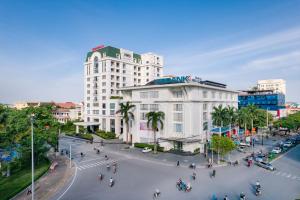 una calle en una ciudad con un gran edificio blanco en Khách sạn Thái Bình Dream, en Thái Bình