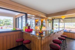 a bar in a restaurant with red stools at Palmarinha de Goa in Calangute