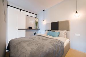 ein Schlafzimmer mit einem großen Bett mit blauen Kissen in der Unterkunft Premium Apartment for Old Town & Jewish Quarter - Balcony plus Pool onsite in Krakau