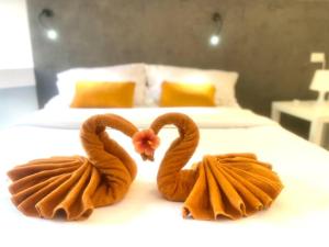 two towels shaped like swans sitting on a bed at STUDIO DESIGN 5 ETOILES Resort in Bang Rak Beach