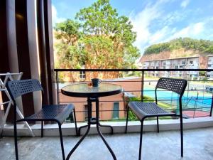 a table and chairs on a balcony with a view of a pool at STUDIO DESIGN 5 ETOILES Resort in Bang Rak Beach