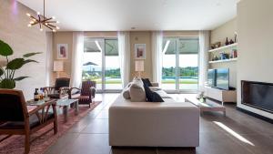 ein Wohnzimmer mit einem weißen Sofa und einem TV in der Unterkunft Villa Atmosfere 8, Emma Villas 