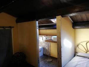 a bedroom with a bunk bed and a bathroom at Casale degli Zappini in Castiglione di Sicilia