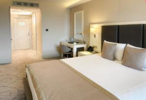 A bed or beds in a room at The Conforium Hotel Van