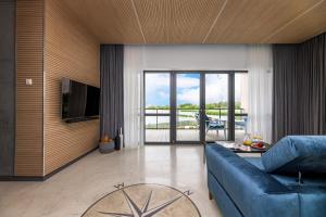 un soggiorno con un divano blu e una TV di SELLING SUNSET, 2BD SEA VIEW Apt, By Cohost a Šventoji