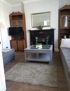 a living room with a coffee table and a fireplace at Recently Renovated House in Heart of Galway City in Galway
