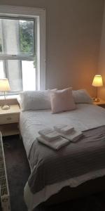 a bedroom with a bed with two towels on it at Recently Renovated House in Heart of Galway City in Galway
