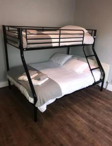 a black bunk bed in a room with a wooden floor at Recently Renovated House in Heart of Galway City in Galway