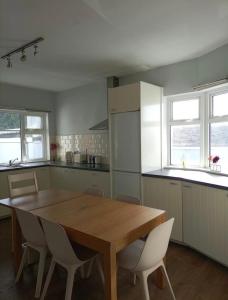 a kitchen with a wooden table and white chairs at Recently Renovated House in Heart of Galway City in Galway