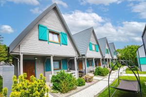 a row of houses with blue shutters at Ośrodek Sea Star Premium in Sarbinowo