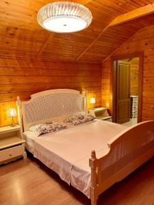 a bedroom with a large bed in a wooden room at Family club Royal-apricot in Tamga