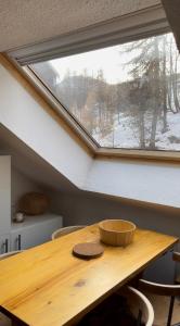 una mesa de madera en una habitación con ventana en Appartement 4 personnes Puy St Vincent 1700 en Puy-Saint-Vincent