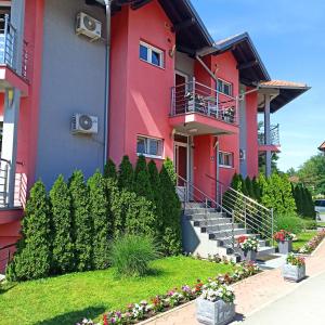 a red building with stairs and flowers in a yard at Stela Et Luna in Veliko Gradište