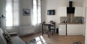 Una cocina con encimera y mesa en una habitación. en Chez Marie Louise, en Pézenas