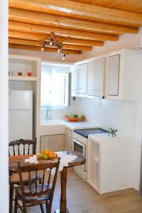 a kitchen with a table and a kitchen with white cabinets at Bonzoe #2 in Parikia +6 photos