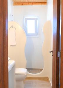 a bathroom with a toilet and a window at Bonzoe #2 in Parikia