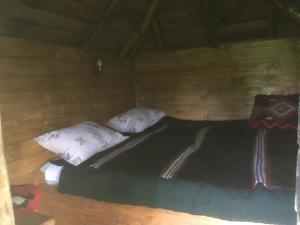 a bed in a wooden room with two pillows at Ambar in Nova Varoš