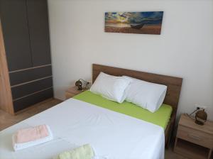 een slaapkamer met een bed met witte en groene lakens bij Spacious 2-bedroom apartment with terrace sea view in Zaboric