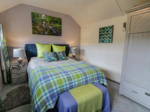 ein Schlafzimmer mit einem Bett mit einer farbenfrohen Tagesdecke in der Unterkunft White Roses Retreat in Betws-y-coed