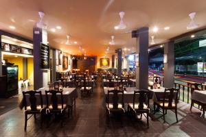Two Chefs Inn في شاطئ كاتا: غرفة طعام مع طاولات وكراسي في مطعم