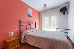 ein rotes Schlafzimmer mit einem Bett und einem Fenster in der Unterkunft Hostal Chelsea in Cedeira