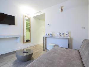 a living room with a couch and a table at Kyriad Paris 18 - Porte de Clignancourt - Montmartre in Paris +38 photos