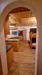 una cucina con arco che conduce a un soggiorno di Casa Cortina - presso Sussy Residence a Falcade