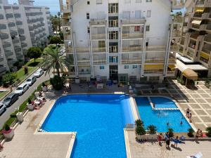 uma vista superior de uma piscina em frente a um edifício em Apartamento con piscina en 1ª línea de playa en Salou em Salou