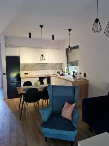 Zbrosławice的住宿－Apartamenty Josef，一间带蓝椅的客厅和一间厨房