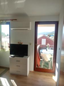 a living room with a television and a balcony at Vala in Božava
