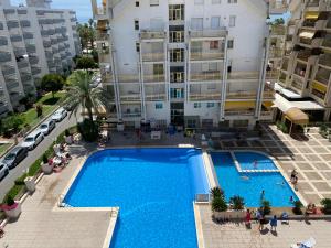 uma vista superior de uma piscina em frente a um edifício em Apartamento con piscina en 1ª línea de playa en Salou em Salou