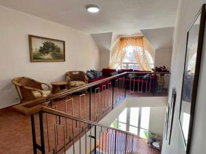 a living room with a staircase with a couch at Tan Nuru Guest House Гостевой Дом Тан Нуру in Cholpon-Ata