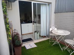 a small patio with a table and chairs on the grass at Grace in Pretoria