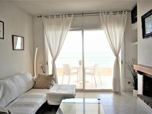 a living room with a white couch and a glass table at Villa Service - Barco 3º in Calafell